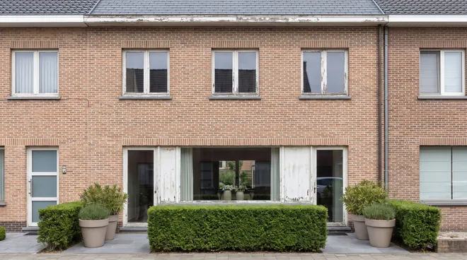 Photo AVANT — châssis blanc vieillissant sur façade brique